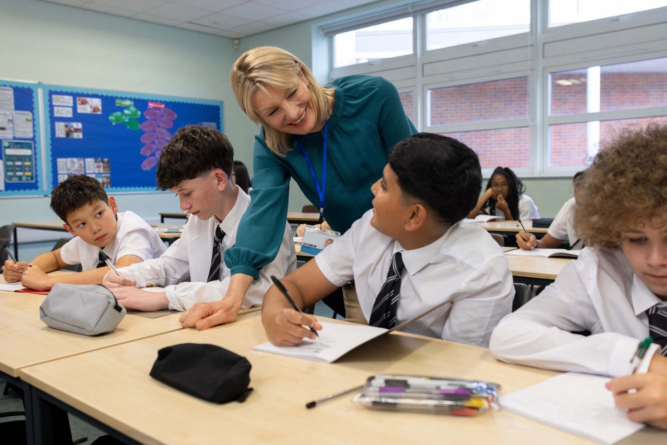 Teacher helping children in a bright classroom