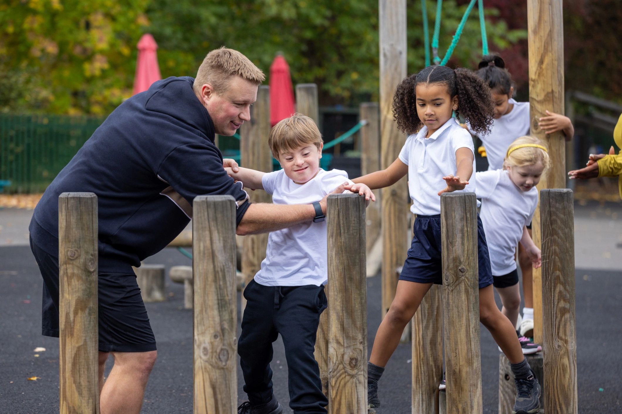 Children practicing balance and coordination on an outdoor obstacle course