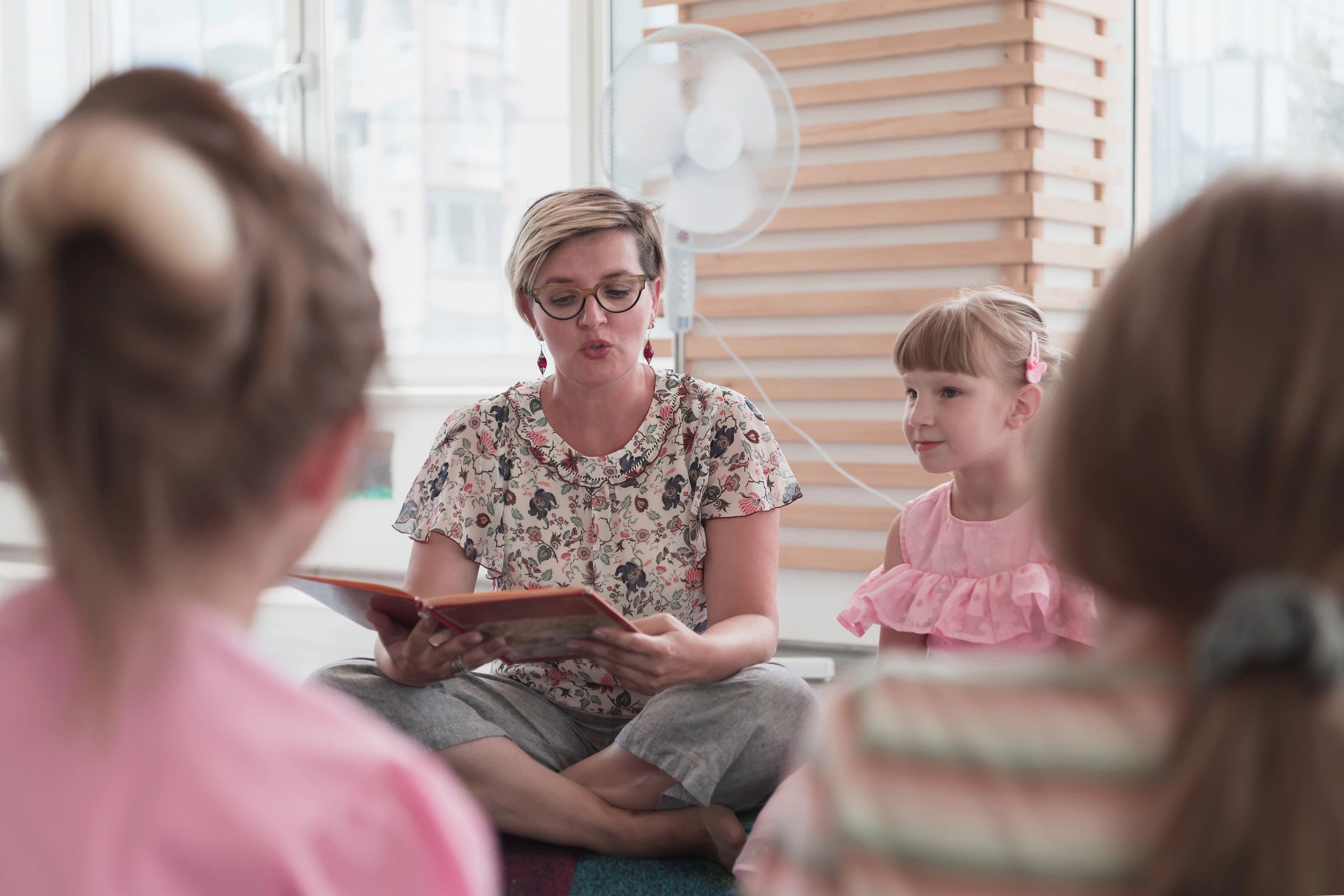 Teacher reading a book to young children during circle time