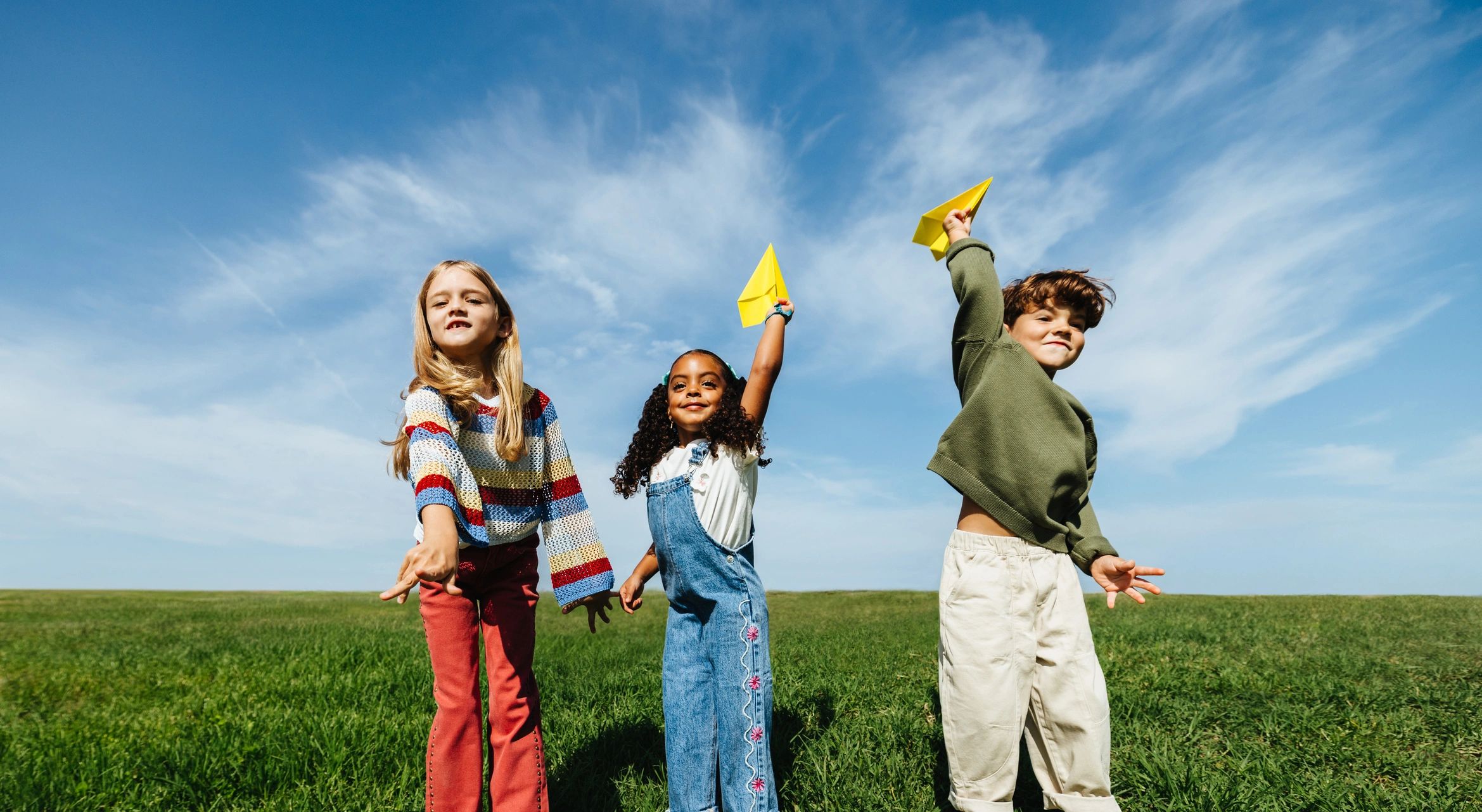 Children playing outdoors with paper airplanes